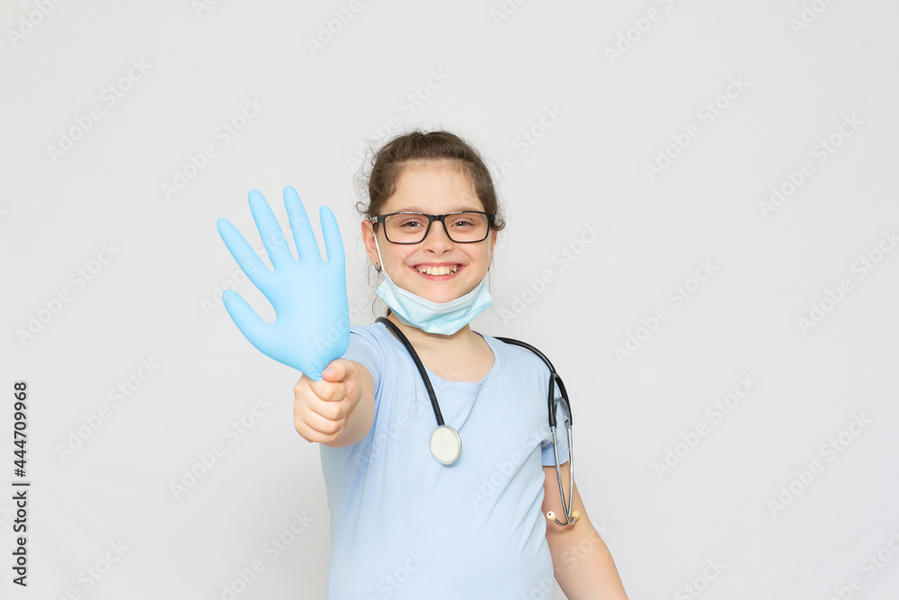 Smiling little girl in medical uniform and blue gloves looking at camera isolated on white Smiling little girl in medical uniform and blue gloves looking at camera isolated on white