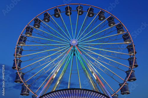 High Ferris Wheel against dark night sky in our summer vacation at Adriatic seaside. Amusement park ride. Holidays concept.