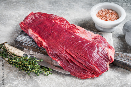 Foto Fresh Flank or flap raw beef steak on wooden board with herbs