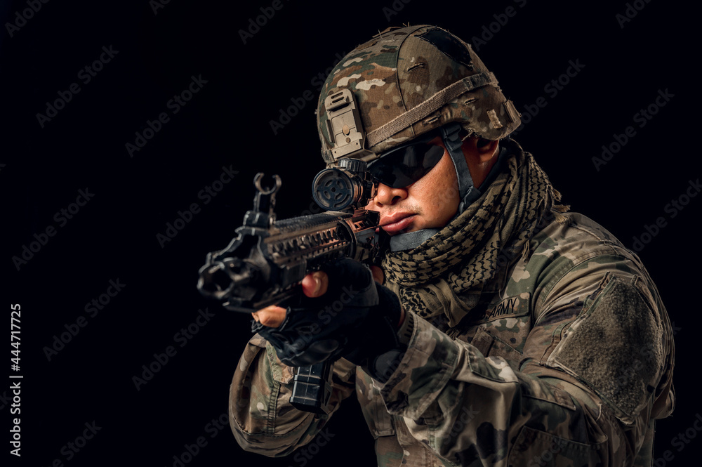 Photo of soldier in black background. Special forces United States soldier or private military contractors holding rifle. Image on black background. soldier, army, war, weapon and technology concept. Photo of soldier in black background. Special forces United States soldier or private military contractors holding rifle. Image on black background. soldier, army, war, weapon and technology concept.