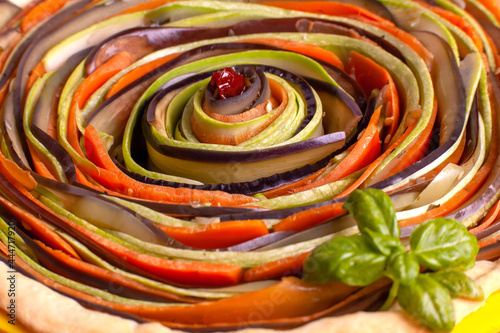Process of cooking vegetable spiral tart with zucchini, eggplant, carrots, bell pepper, basil in silicone baking dish
