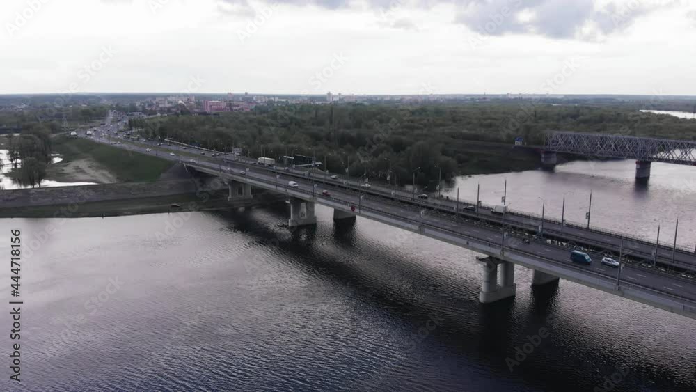 Aerial view of busy traffic on the double bridge over the river and the trees flooded during the flood on the bank Aerial view of busy traffic on the double bridge over the river and the trees flooded during the flood on the bank