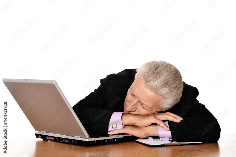 Old businessman sleeping at table with laptop Old businessman sleeping at table with laptop