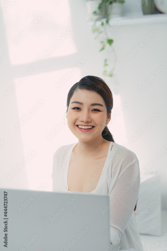 Young woman using laptop computer on a cold winter day in the bedroom. Young woman using laptop computer on a cold winter day in the bedroom.