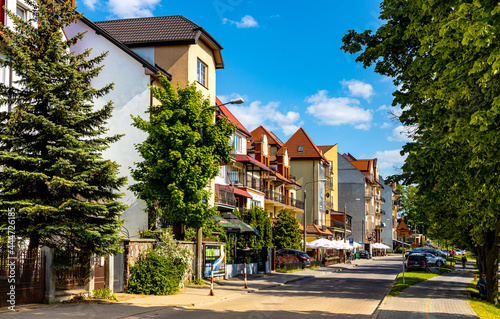 Fototapeta Naklejka Na Ścianę i Meble -  Panoramic view of lake promenade ulica Pulaskiego street with tourist pensions and restaurants along Jezioro Elckie lake shore in Elk town in Masuria region of Poland