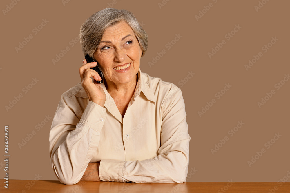 Beautiful senior woman talking on phone at home Beautiful senior woman talking on phone at home