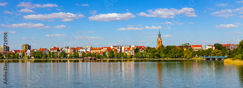 Panorama of Elk historic city center with Holiest Heart of Jesus neo-gothic church tower on shore of Jezioro Elckie lake in Masuria region in Poland