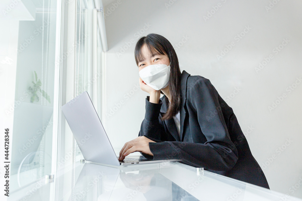 Asian woman wear mask and using laptop in coffee shop. Asian woman wear mask and using laptop in coffee shop.