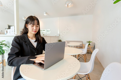 Asian woman using laptop in coffee shop
