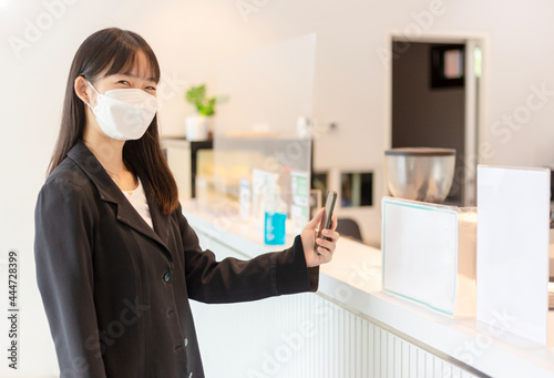 Asian woman scan for pay money in shop.