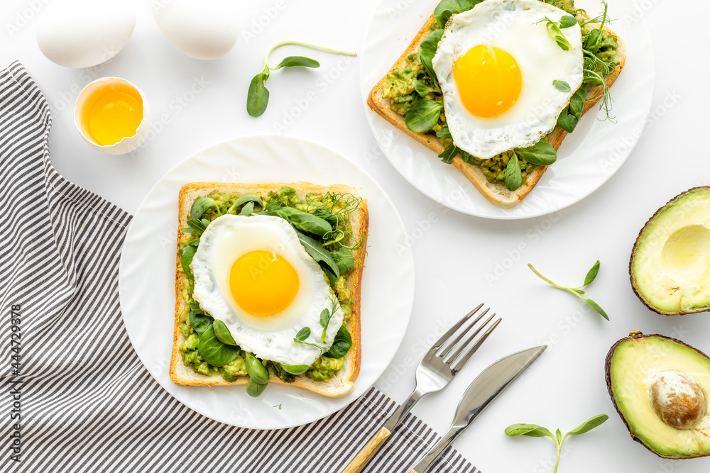 Breakfast with toasts of fried eggs and avocado saurce. Top view Breakfast with toasts of fried eggs and avocado saurce. Top view