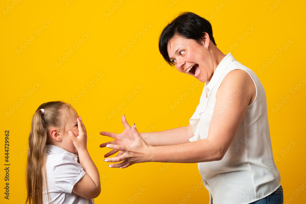 Mother screams shouts at little daughter scolding her. Kid not listen ignoring mom close cover her ears with fingers. Complicated relationships with child and family conflict concept. Mother screams shouts at little daughter scolding her. Kid not listen ignoring mom close cover her ears with fingers. Complicated relationships with child and family conflict concept.