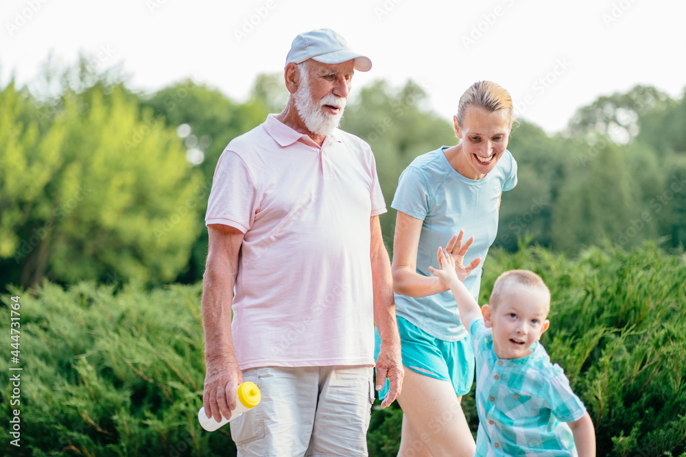 Summer, sport, outdoor activities concept. Happy and cheerful grandfather walking outdoor with his daughter and grandson. Portrait of multi generation family spending time together in park. Summer, sport, outdoor activities concept. Happy and cheerful grandfather walking outdoor with his daughter and grandson. Portrait of multi generation family spending time together in park.