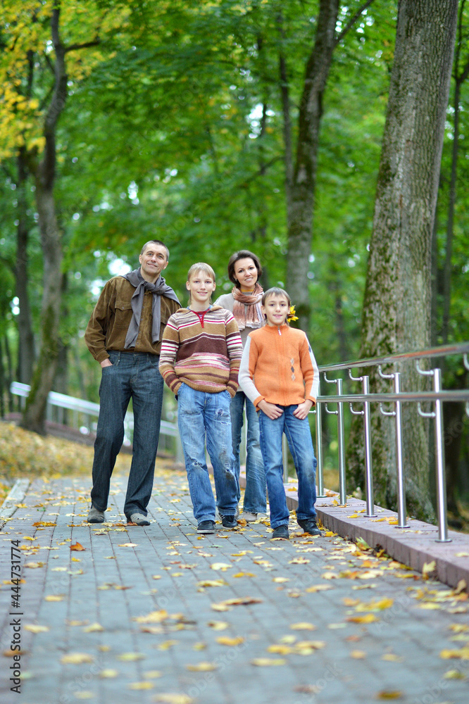 Family of four walking in autumn park Family of four walking in autumn park