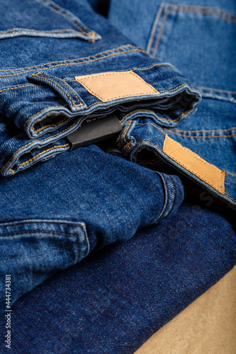 Stack of variety blue jeans, denim jean textiles as background. different blue jeans trousers stack textile texture fabric background