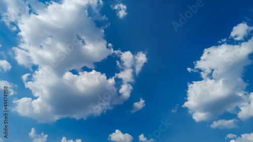 White cumulus clouds in the sky on a sunny summer day.