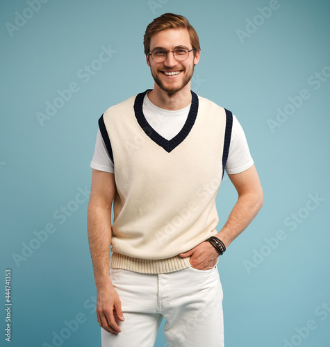 Young handsome man with beard wearing casual shirt standing over blue background