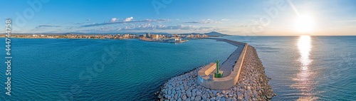 Drone panorama of the Spanish town of Vinaros with the large breakwater at the entrance to the port during sunrise
