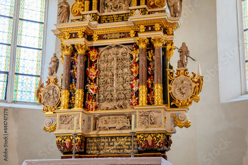 Krasne Brezno, Bohemia, Czech Republic, 26 June 2021: Saxony style renaissance church of St. Florian, temple interior with alabaster reliefs of the altar, wooden benches standing in row