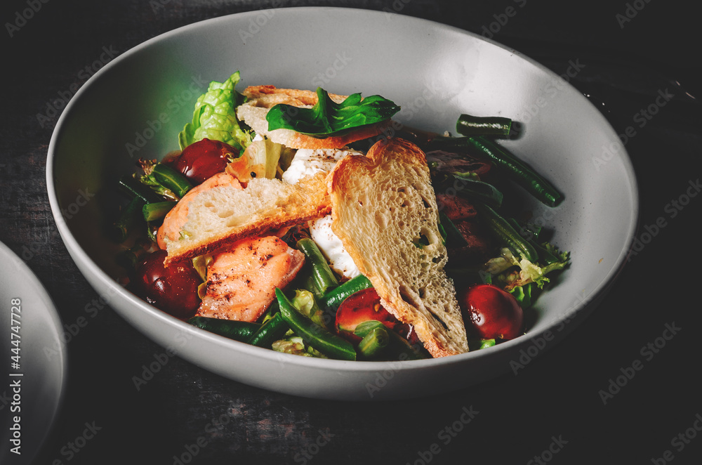 Green Bean Salad with Boiled Eggs, Salmon, Tomatoes and Arugula in a bowl on Dark grey black slate background Green Bean Salad with Boiled Eggs, Salmon, Tomatoes and Arugula in a bowl on Dark grey black slate background