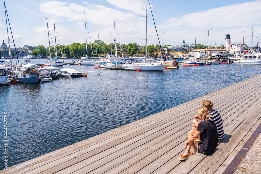 Obraz premium Stockholm Sweden - July 4 2021: Relaxing atmosphere in the port of Djurgarden. Sunny weather and peaceful atmosphere. Popular tourist destination in Scandinavia.