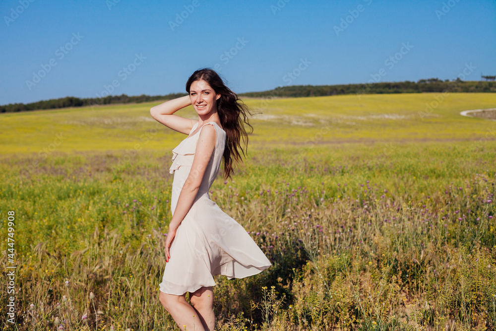 a beautiful woman in a dress walking in a field in nature a beautiful woman in a dress walking in a field in nature