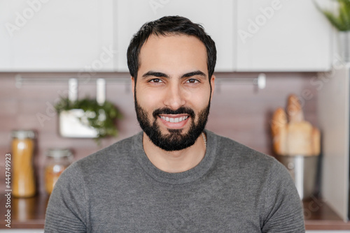 Fotografija Close up portrait of mature young Middle Eastern Arabian muslim islamic handsome man showing toothy smile looking in camera