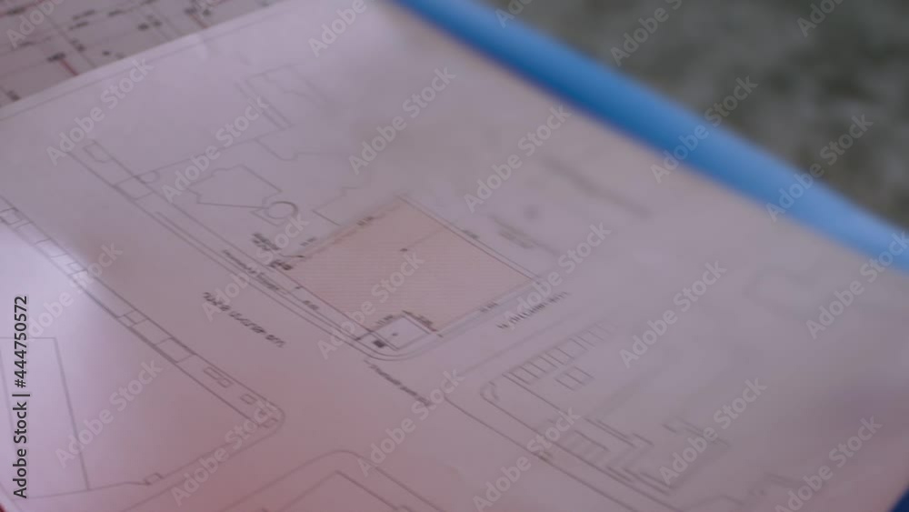 Group of three professional engineers with protective uniform opening the blueprint of building project and discussing . Foremen bringing the map of the plan of construction and talking . Slow motion Group of three professional engineers with protective uniform opening the blueprint of building project and discussing . Foremen bringing the map of the plan of construction and talking . Slow motion