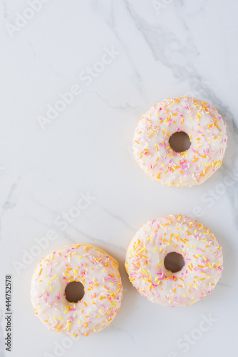 Donuts on white marble surface. Photo flat lay, top view.