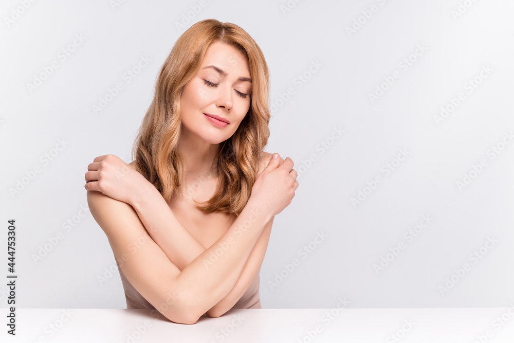 Portrait of attractive dreamy woman sitting hugging herself wash shower gel scrub isolated over grey pastel color background Portrait of attractive dreamy woman sitting hugging herself wash shower gel scrub isolated over grey pastel color background