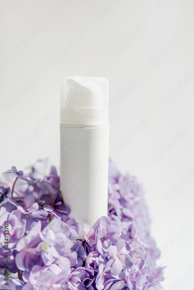 Cosmetic bottle and flowers on a white background. Cosmetic bottle and flowers on a white background.