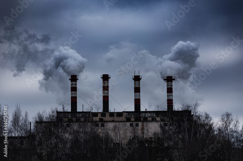 Factory chimneys from which there is dense gray smoke 
