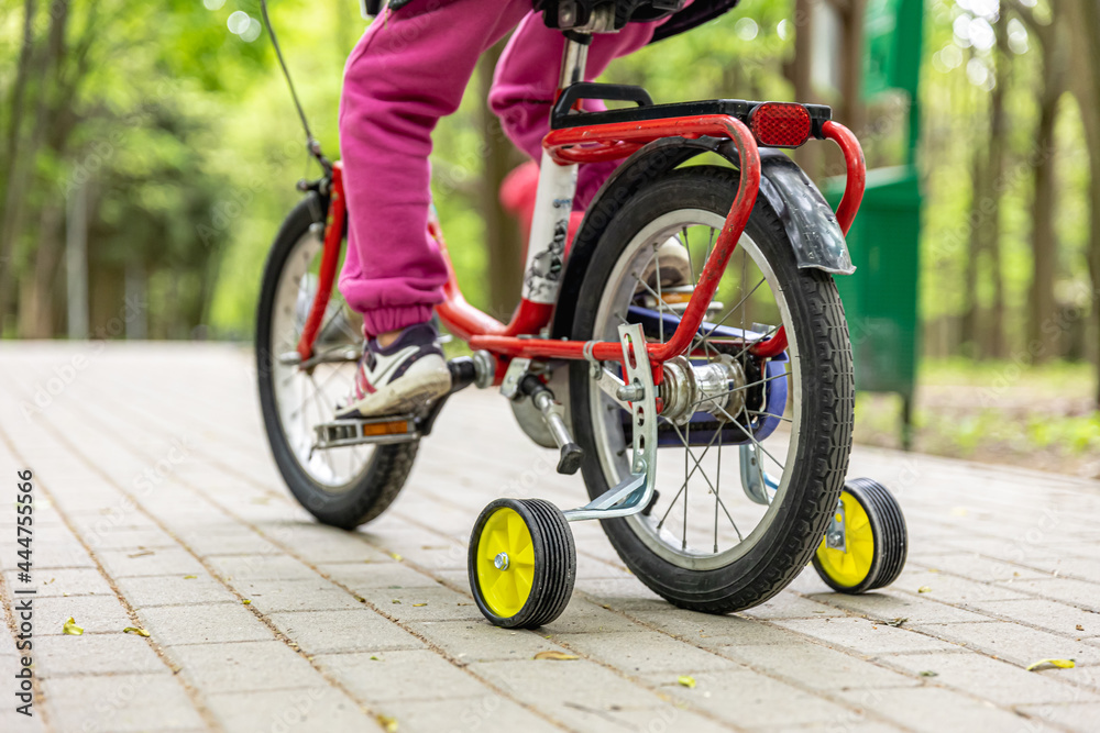 Naklejka premium The child is riding a tricycle in the park.