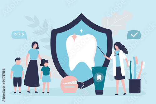 Woman dentist explains to mother with children how to properly maintain oral hygiene. Various dental tools. Specialist shows how to clean teeth. Healthсare, pediatric dentistry.