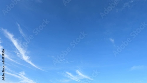 white cirrus clouds in sunny clear blue sky