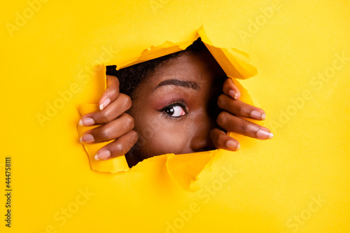 Photo of charming interested woman ripped torn blank space look through bright yellow color background © deagreez