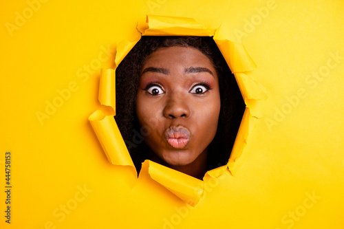 Photo of romantic affectionate woman pouted lips send air kiss look through bright yellow color background © deagreez