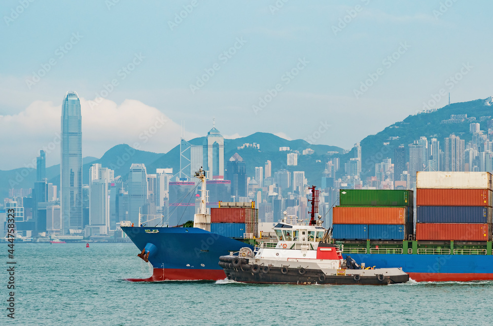 Cargo ship in Victoria Harbor of Hong Kong city - obrazy, fototapety, plakaty 