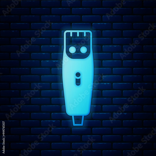 Glowing neon Electrical hair clipper or shaver icon isolated on brick wall background. Barbershop symbol. Vector