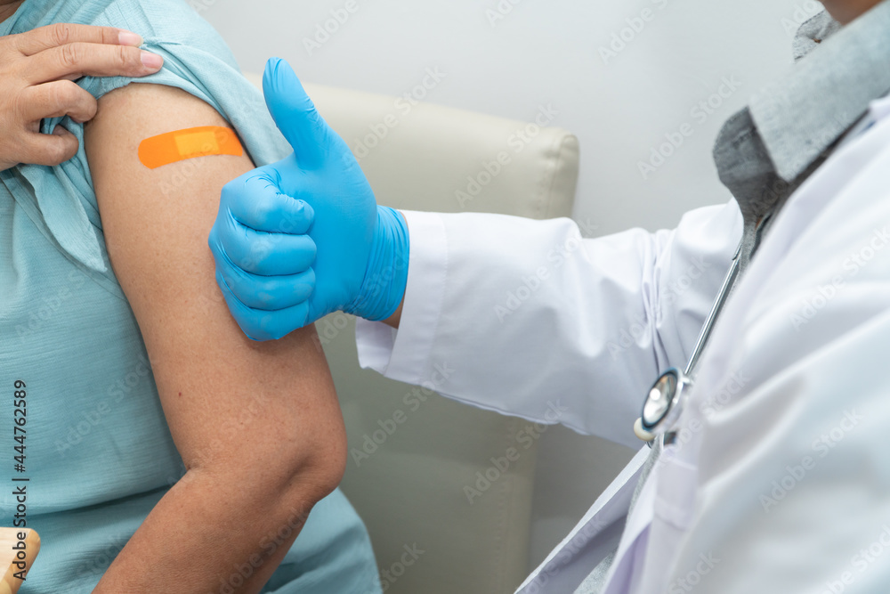 Doctors wear medical masks are put on medicinal plaster after vaccinated senior women patients for the prevention of coronavirus and flu. Concept of immunization from inoculation Doctors wear medical masks are put on medicinal plaster after vaccinated senior women patients for the prevention of coronavirus and flu. Concept of immunization from inoculation