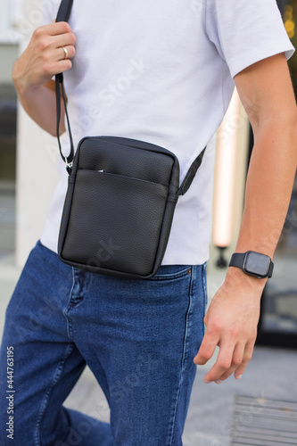 Closeup man holding black leather messenger bag