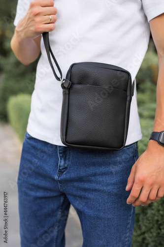 Closeup man holding black leather messenger bag