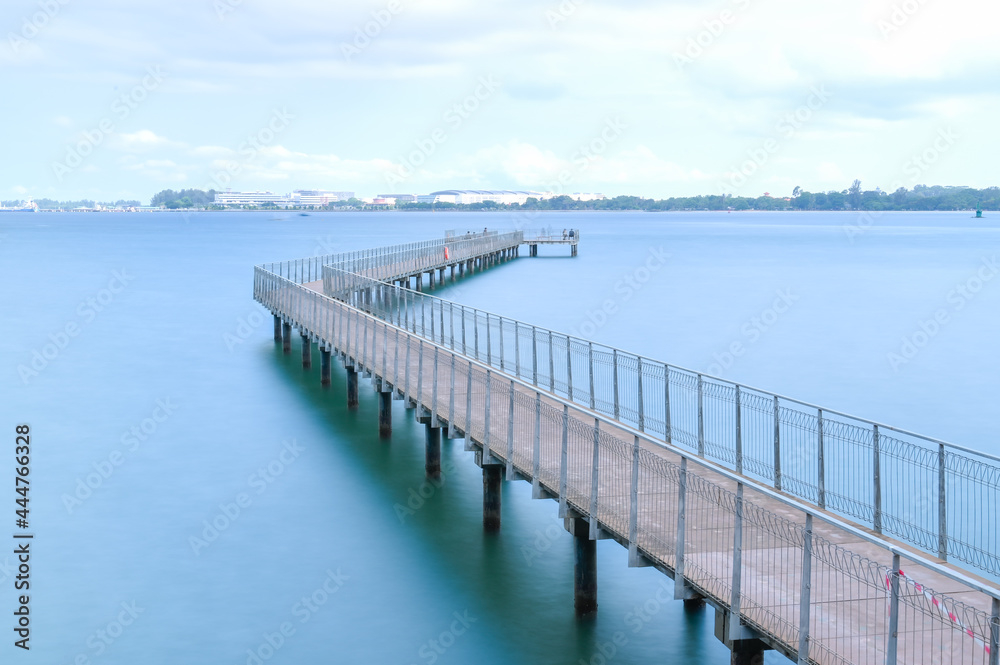 A pier or dock extending into the calm blue sea.