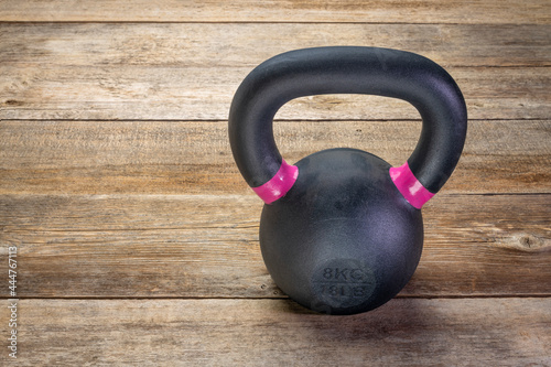 Fototapeta Naklejka Na Ścianę i Meble -  small iron kettlebell on a rustic wood background with a copy space,  fitness concept