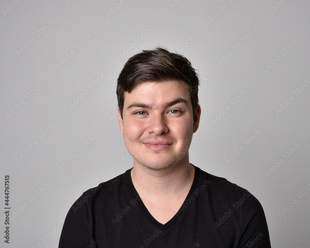 Close up head and shoulders portrait of a brunette. young man with a variety of expressive facial expressions. Isolated on a light grey studio background. Close up head and shoulders portrait of a brunette. young man with a variety of expressive facial expressions. Isolated on a light grey studio background.