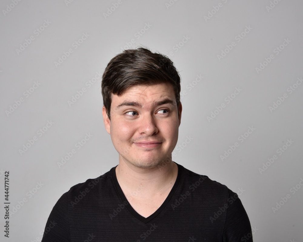 Close up head and shoulders portrait of a brunette. young man with a variety of expressive facial expressions. Isolated on a light grey studio background. Close up head and shoulders portrait of a brunette. young man with a variety of expressive facial expressions. Isolated on a light grey studio background.