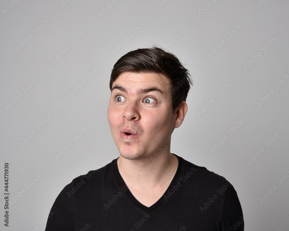 Close up head and shoulders portrait of a brunette. young man with a variety of expressive facial expressions. Isolated on a light grey studio background. Close up head and shoulders portrait of a brunette. young man with a variety of expressive facial expressions. Isolated on a light grey studio background.