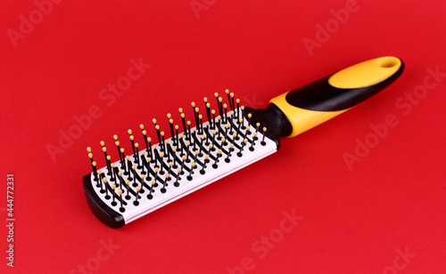 White ceramic hairbrush on a red background