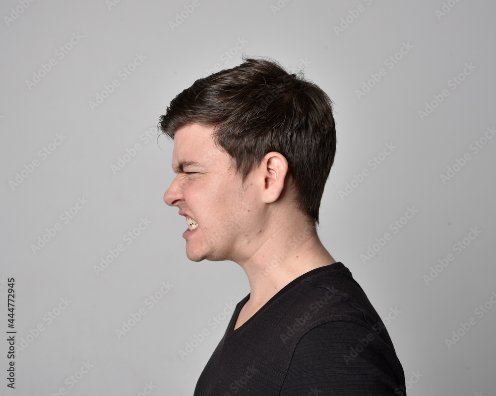 Close up head and shoulders portrait of a brunette. young man with a variety of expressive facial expressions. Isolated on a light grey studio background. Close up head and shoulders portrait of a brunette. young man with a variety of expressive facial expressions. Isolated on a light grey studio background.