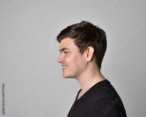 Close up head and shoulders portrait of a brunette. young man with a variety of expressive facial expressions. Isolated on a light grey studio background.